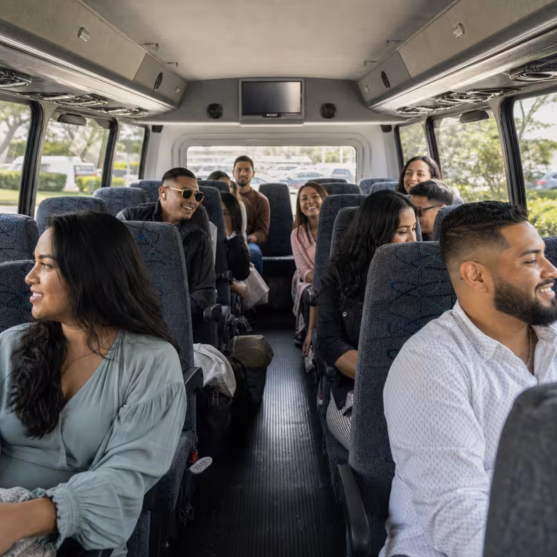 Group boarding a white charter bus for Private Event Transportation transportation in Phoenix