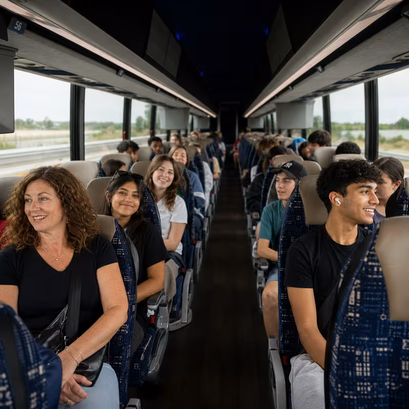 Group boarding a white charter bus for School Transportation transportation in Phoenix