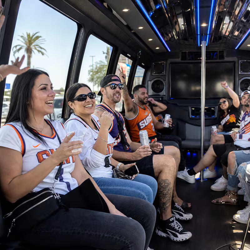 Group boarding a white charter bus for Sporting Event Transportation transportation in Phoenix