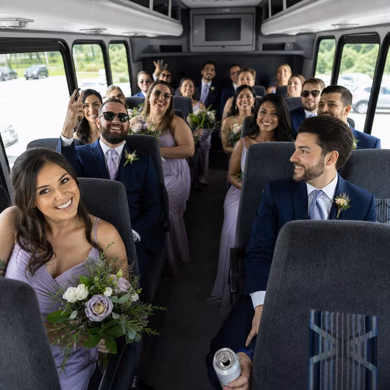 Group boarding a white charter bus for Wedding Transportation transportation in Phoenix